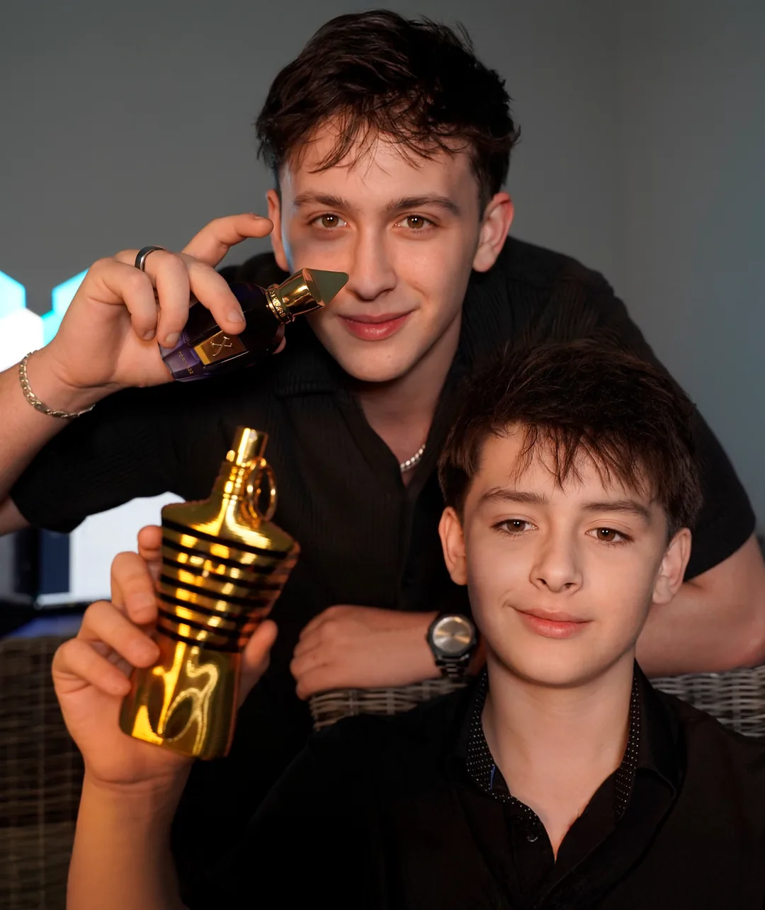 Jordan and Lil Bro holding two fragrance bottles
